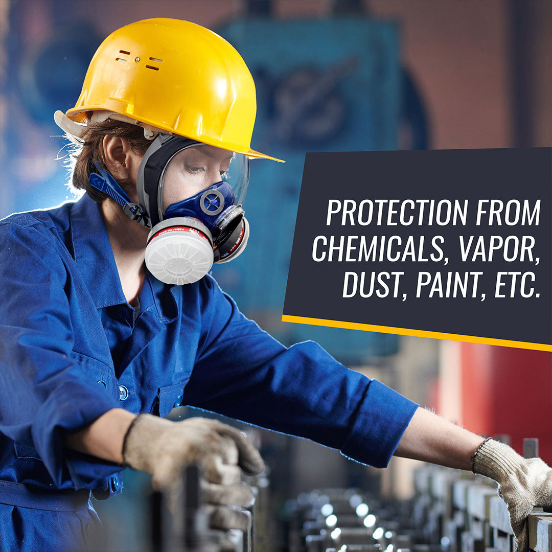 Person wearing a yellow hard hat, blue protective suit, and respirator mask in an industrial setting.